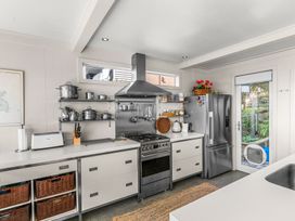 A kitchen with shelves and appliances at Oli Kai - Algies Bay Holiday Home in Algies Bay