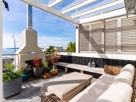 An outdoor deck with seating and a fireplace at Oli Kai - Algies Bay Holiday Home Algies Bay