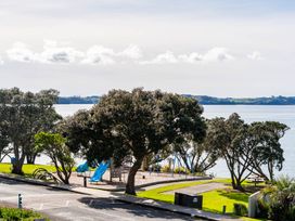 A playground with trees and a view of the water at Oli Kai - Algies Bay Holiday Home, Algies Bay