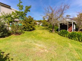 A garden with grass and trees at Oli Kai - Algies Bay Holiday Home in Algies Bay