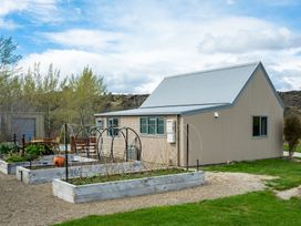 A shed with garden beds and plants at a property