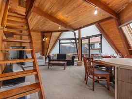 A living room with stairs, sofa, dining area, and windows at The Old Barn in 