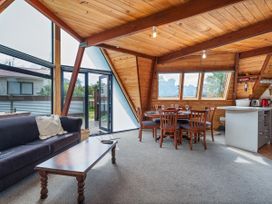 A living room with a sofa and dining area at a property