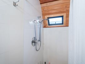 A shower with a window and shower fixtures at a property