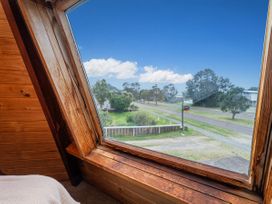 A bedroom with a view of trees and a road at the property