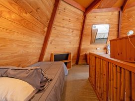 A bedroom with a bed, nightstand, and mirror at a cabin in an outdoor location
