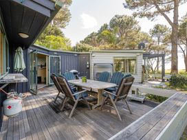 An outdoor dining area with a table and chairs at a property in Whitianga