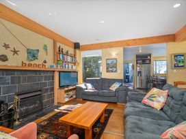 A living room with a fireplace and furniture at the beach house in Whitianga