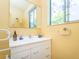 A bathroom with a sink and mirror at The Old Barn in Whitianga