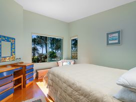 A bedroom with a bed and a dresser at The Old Barn in Whitianga