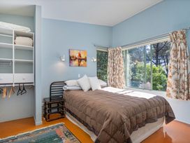 A bedroom with a bed and shelving at the property in Whitianga