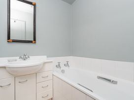 A bathtub and sink with a mirror at the property in Whitianga