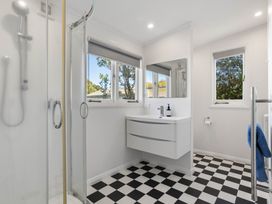 A bathroom with a shower, sink, and two windows at the property in 