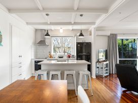 A kitchen with an island, bar stools, and a refrigerator at the property in location