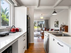 A kitchen with appliances and view to outdoor seating area at the property