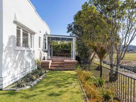 A house exterior with a deck and lawn at the property in unspecified location