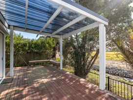 An outdoor deck with a bench and trees at a property