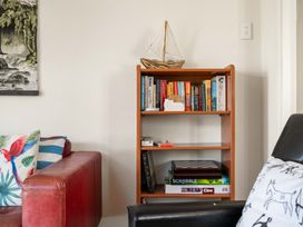 A bookshelf with books and games in a living room