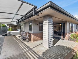 An outdoor area with a hot tub and patio furniture at Nukuhau Bliss - Taupo Holiday Home Taupo Central