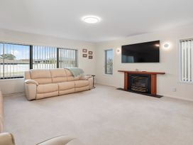 A living room with a sofa and television at Nukuhau Bliss - Taupo Holiday Home Taupo Central