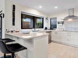 A kitchen with bar stools and appliances at Nukuhau Bliss - Taupo Holiday Home Taupo Central