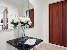 An entryway with a mirror and a floral arrangement at Nukuhau Bliss - Taupo Holiday Home Taupo Central
