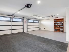A garage with a bookshelf and tools at Nukuhau Bliss - Taupo Holiday Home Taupo Central