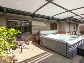 An outdoor area with a hot tub and chairs at Nukuhau Bliss - Taupo Holiday Home, Taupo Central