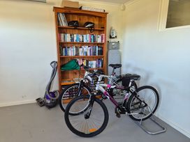 A garage with bicycles and a bookshelf at Nukuhau Bliss - Taupo Holiday Home