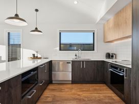 A kitchen with cabinets and appliances at Harper on Hadley - Cromwell Holiday Home