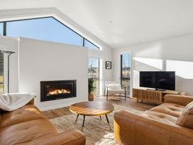 A living room with a fireplace and television at Harper on Hadley - Cromwell Holiday Home Cromwell