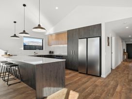 A kitchen with an island and bar stools at Harper on Hadley - Cromwell Holiday Home, Cromwell