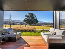 An outdoor seating area with sofas facing a park at Harper on Hadley - Cromwell Holiday Home in Cromwell