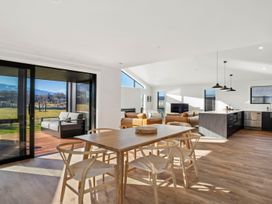 A living area with a dining table and kitchen island at Harper on Hadley - Cromwell Holiday Home Cromwell