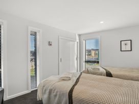 A bedroom with two beds and a window at Harper on Hadley - Cromwell Holiday Home, Cromwell