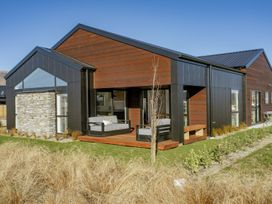 A house with a deck and sofa surrounded by garden at Harper on Hadley - Cromwell Holiday Home