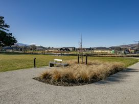 A park with a bench and a pathway alongside grass and trees at Harper on Hadley - Cromwell