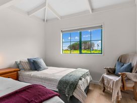 A bedroom with two beds and a window at Waipu in Waipu