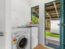 A laundry room with a washing machine and a sink at Waipu in Waipu