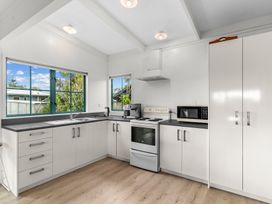 A kitchen with a stove and microwave at Waipu in Waipu