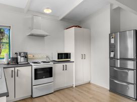A kitchen with an oven, microwave, and refrigerator at Waipu