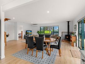 A living room with a dining table and chairs at Waipu, Waipu