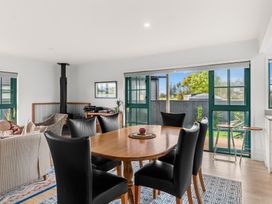 A dining room with a table and chairs at Waipu in Waipu