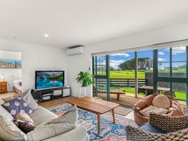 A living room with a sofa and television at Waipu