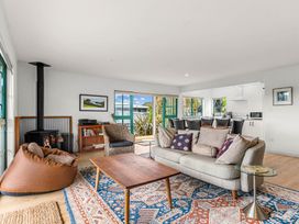 A living room with a sofa, coffee table, and fireplace at Waipu, Waipu