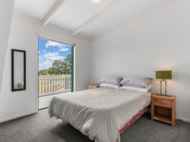 A bedroom with a bed and a window at Waipu in Waipu