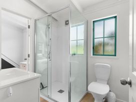 A bathroom with a shower, toilet, and sink at Waipu