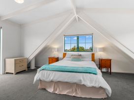 A bedroom with a bed and nightstands at Waipu in Waipu