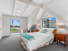 A bedroom with a bed and nightstands at Waipu in Waipu
