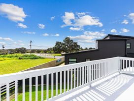 A balcony view with grass and trees at Waipu